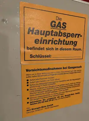 Gas-Hauptabsperreinrichtung in einem Technikraum mit Sicherheitshinweisen, Fokus auf Gasversorgung, Sicherheit und Unfallprävention.